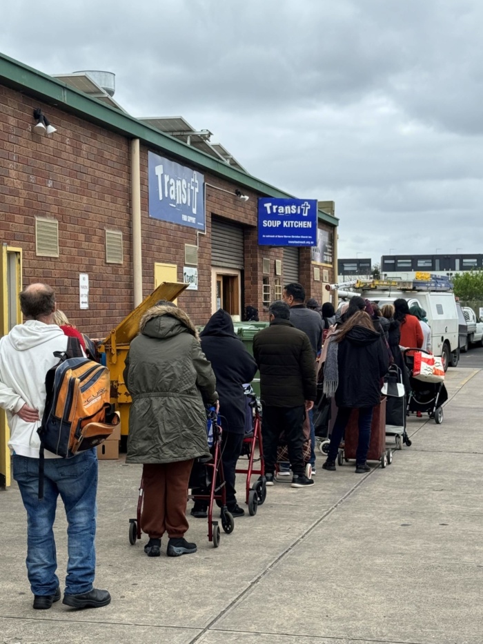People in need line up for help at Transit Soup Kitchen